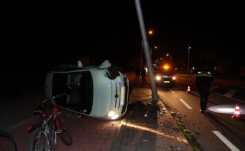 Auto belandt op zijkant na botsing tegen paal in Lisse