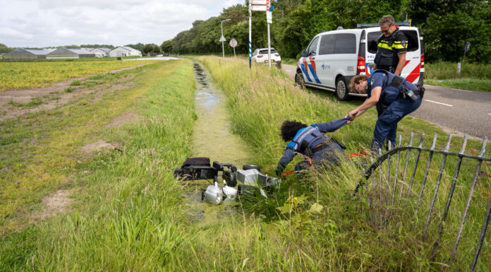 Omstanders halen vrouw in scootmobiel uit het water in Noordwijkerhout