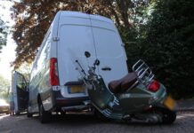 Scooter vast onder bus van pakketbezorger in Voorhout