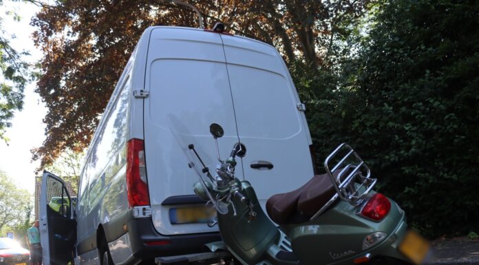 Scooter vast onder bus van pakketbezorger in Voorhout